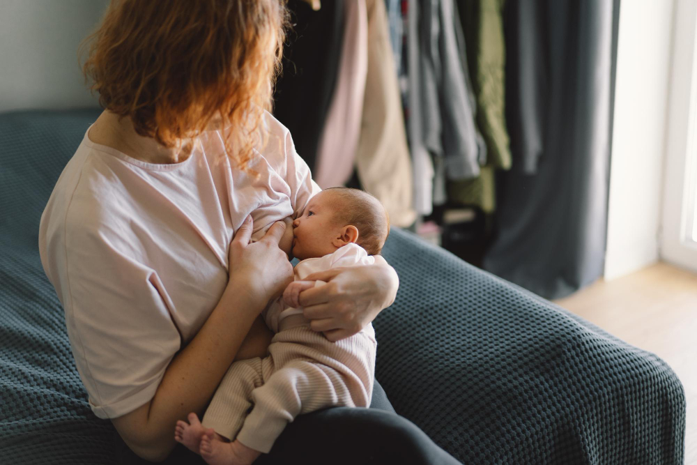 A mother sitting on her bed breastfeeding her baby